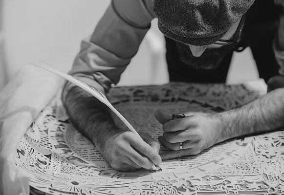 Ilan Atlan creating a detailed paper-cut artwork